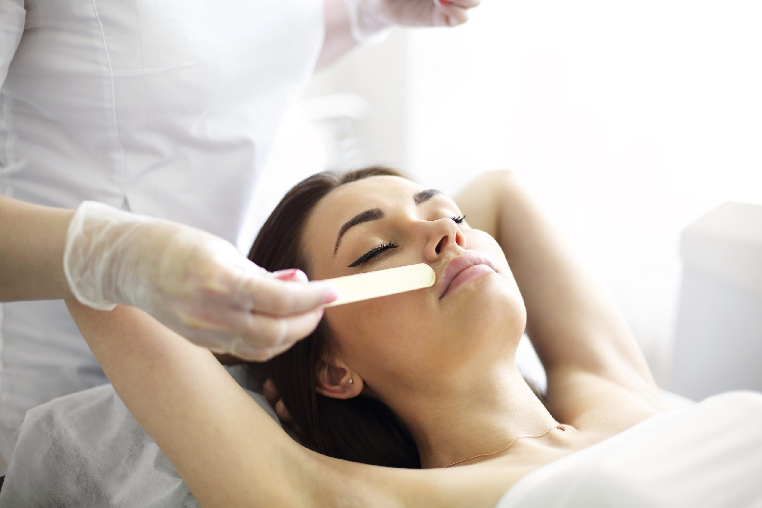 Woman receiving a professional facial waxing service